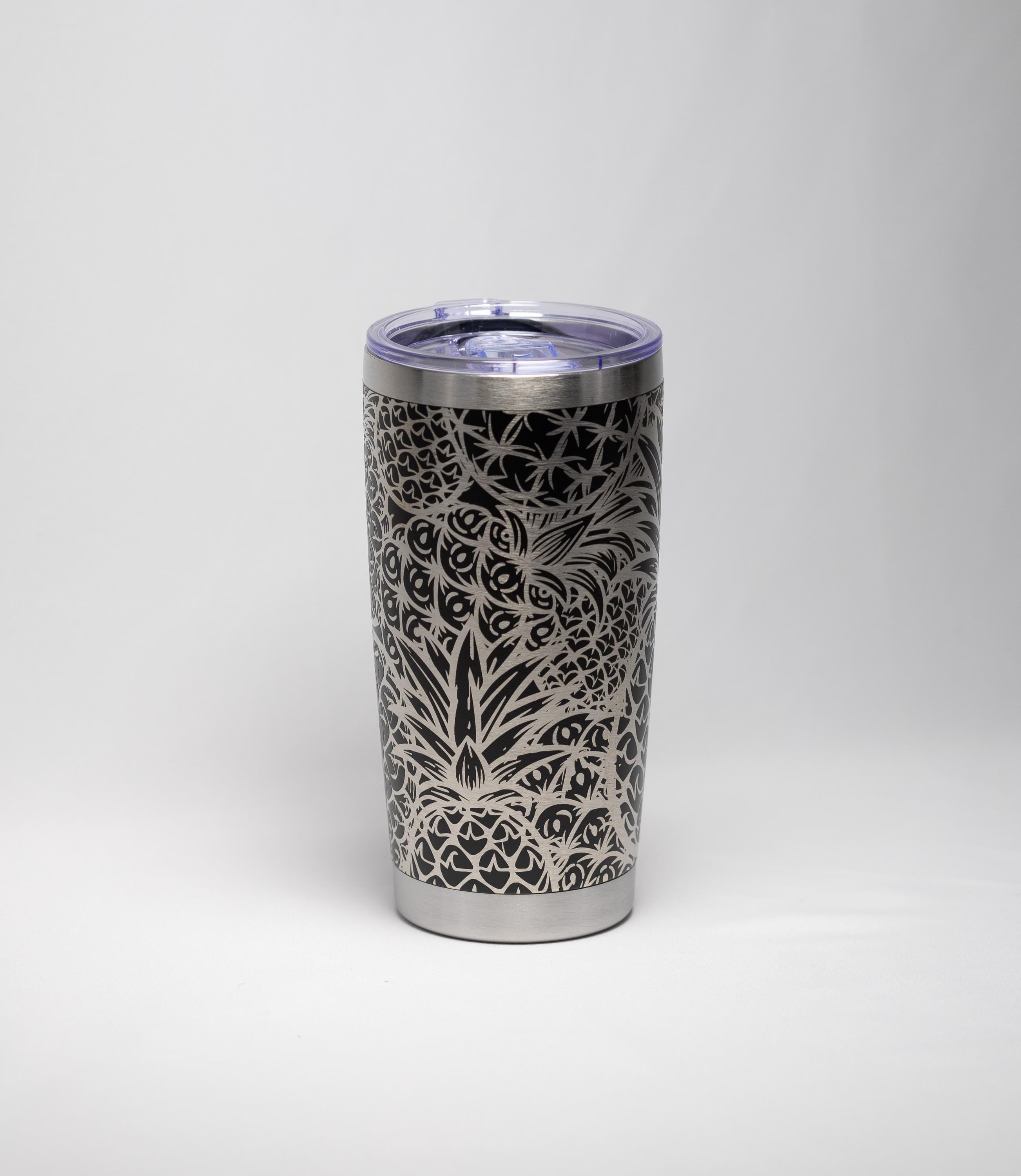 May include: A stainless steel travel tumbler with a black pineapple design. The tumbler has a clear lid and a silver rim at the top and bottom. The pineapple pattern is etched into the black surface.