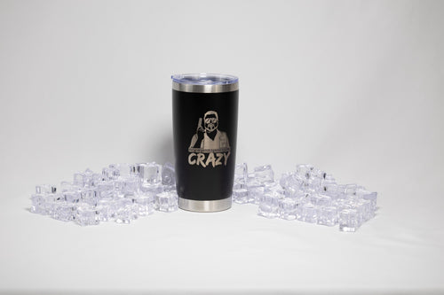 A black tumbler with a silver lid, featuring a printed design, is surrounded by numerous clear ice cubes on a white background.