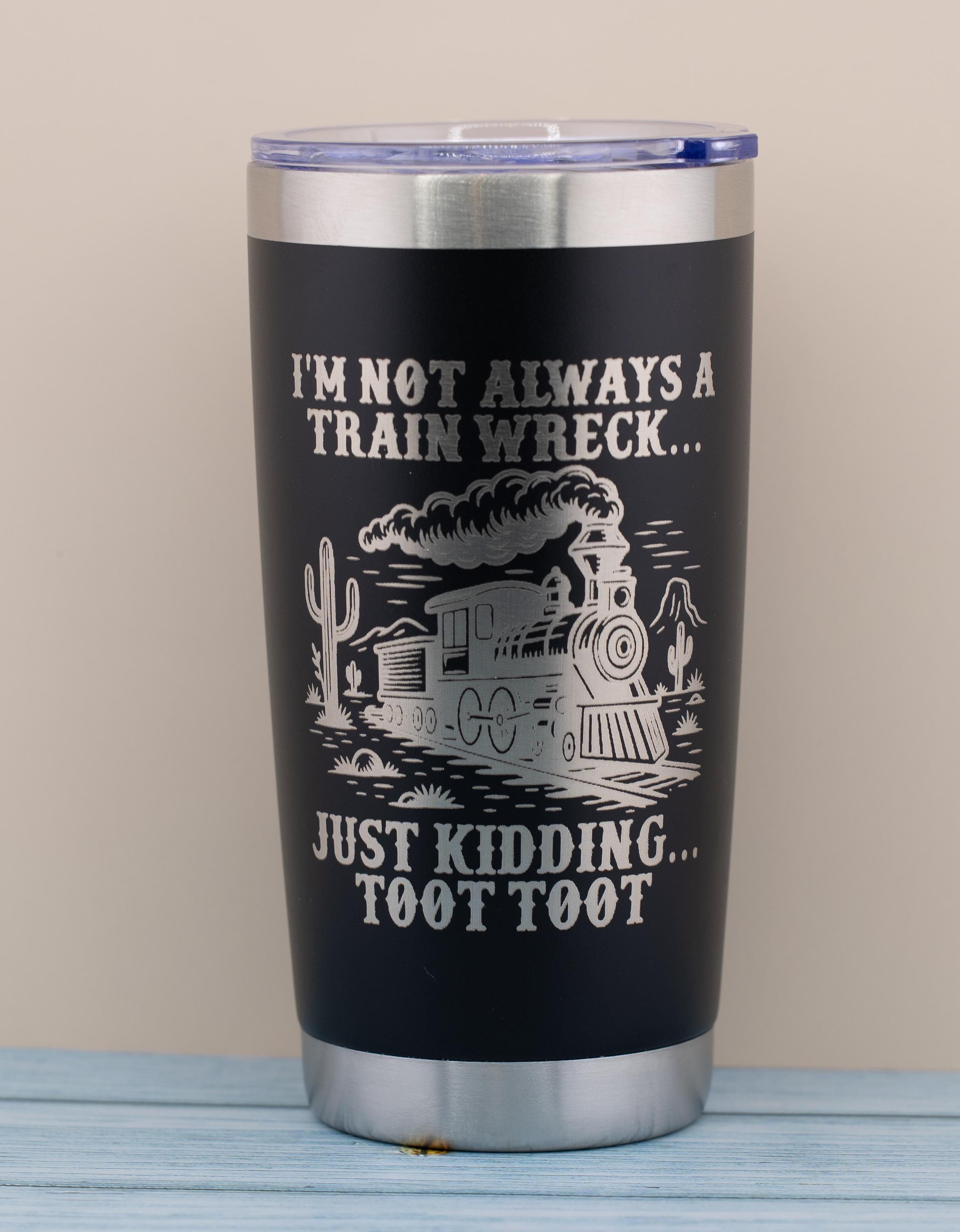 A black tumbler with a printed design on it, featuring a train and text that reads "I'm not always a train wreck... just kicking toot toot".