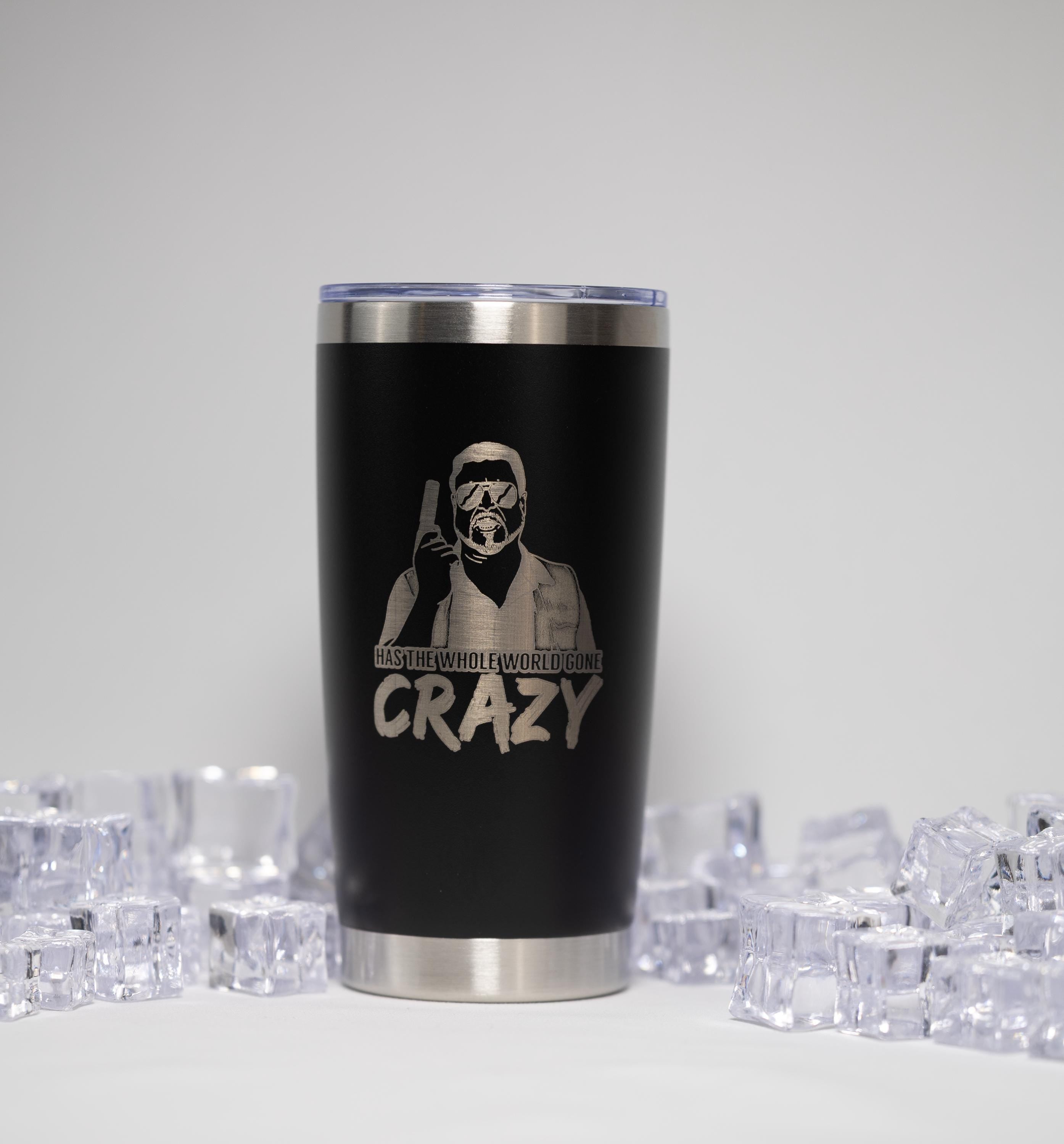 A black tumbler with a silver lid, featuring a printed design of a person wearing a helmet and goggles, along with the text "HAZY THE WHOLE WORLD GOES CRAZY".