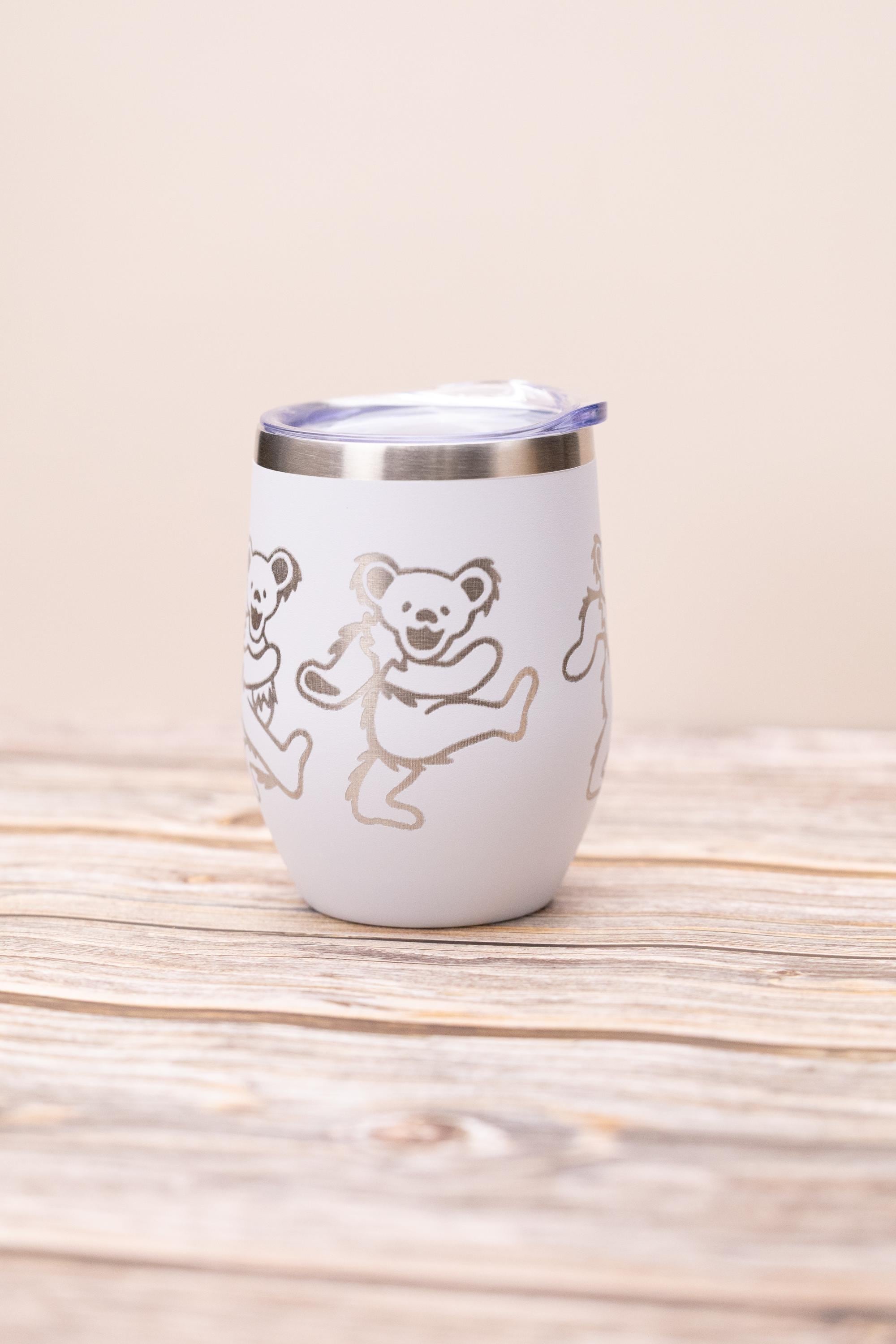 May include: White insulated tumbler with a silver rim and a clear lid. The tumbler features a repeating pattern of dancing bears in a silver color. The tumbler is designed to keep beverages cold or hot.