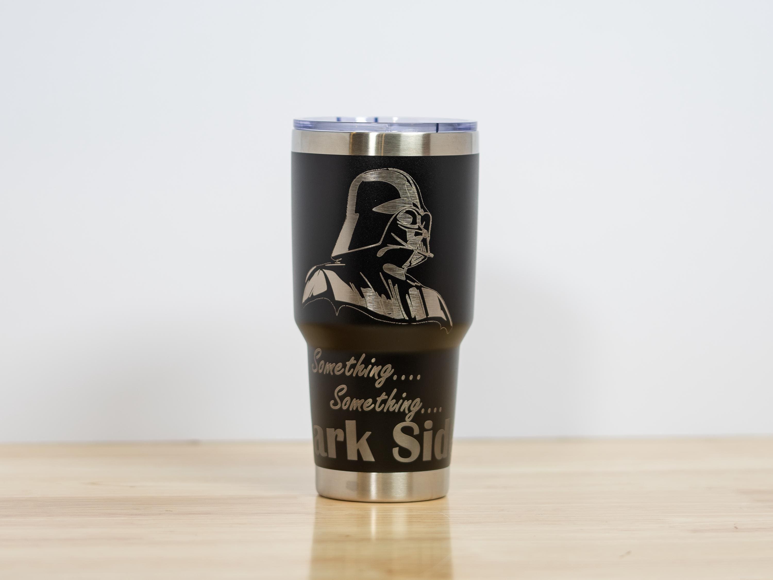 May include: Black stainless steel tumbler featuring an engraved image of Darth Vader and the words "Something... Something... Dark Side." The tumbler has a silver lid and base, perfect for fans of the Star Wars franchise.