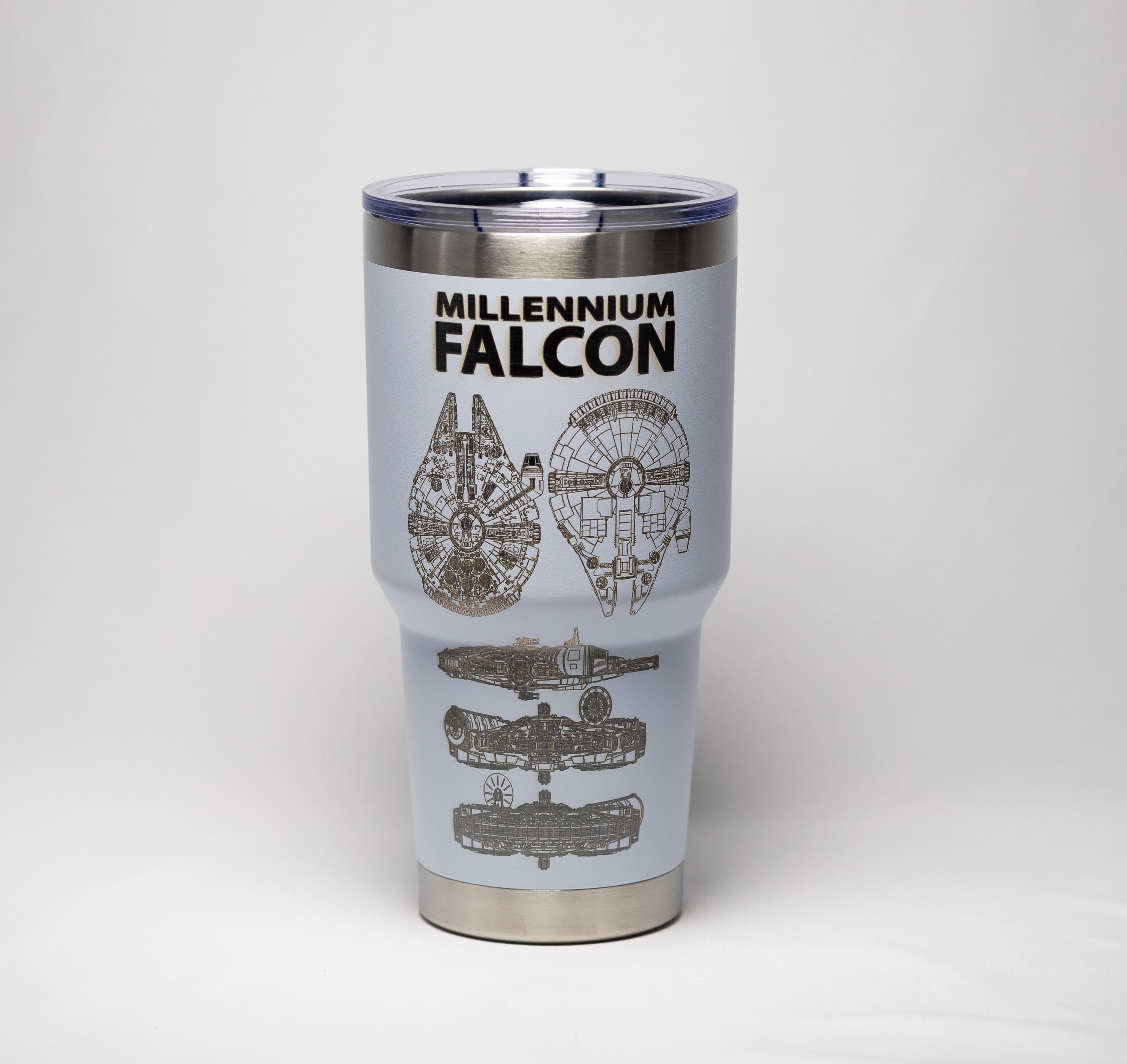 May include: A light blue travel mug with a silver rim and lid. The mug features the words "MILLENNIUM FALCON" in black, along with detailed illustrations of the spacecraft.