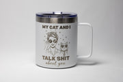 May include: White travel mug with a black lid and handle. The mug features a graphic of a woman and a cat wearing sunglasses, with the text "MY CAT AND I TALK SHIT about you."