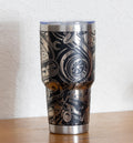 May include: Stainless steel tumbler with a black background and a detailed silver-colored engine parts design. The tumbler has a clear lid and a silver base and rim. The design includes gears, turbochargers, and other mechanical components.