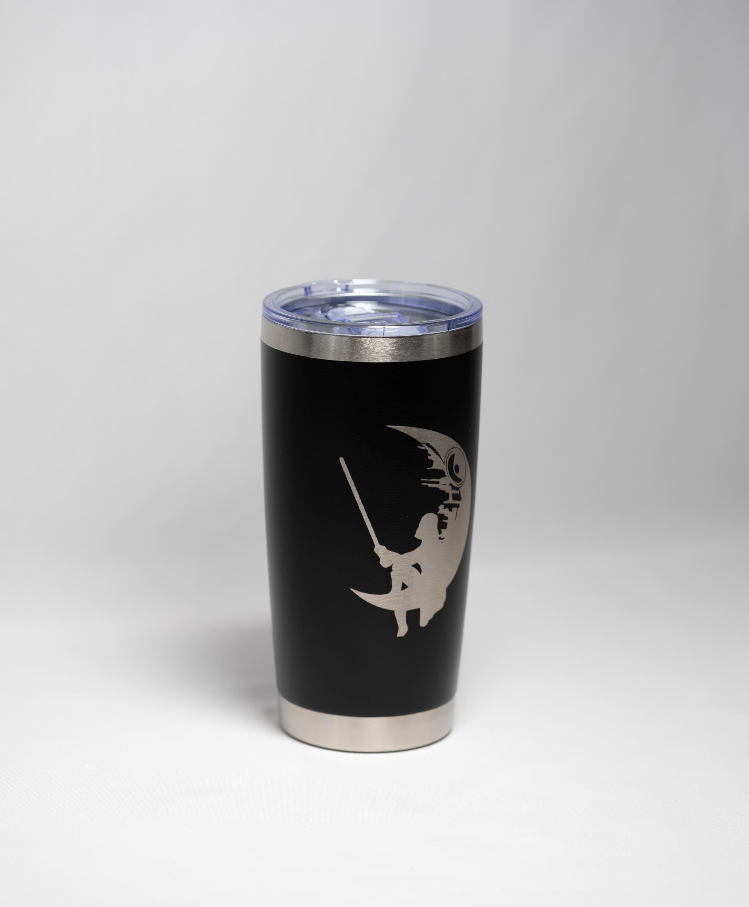 A black tumbler with a silver lid and a silver silhouette of a person fishing on the side.