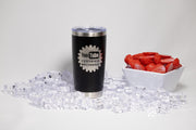 A black tumbler with a white logo and text, a white bowl filled with red strawberries, and a pile of clear ice cubes on a white background.