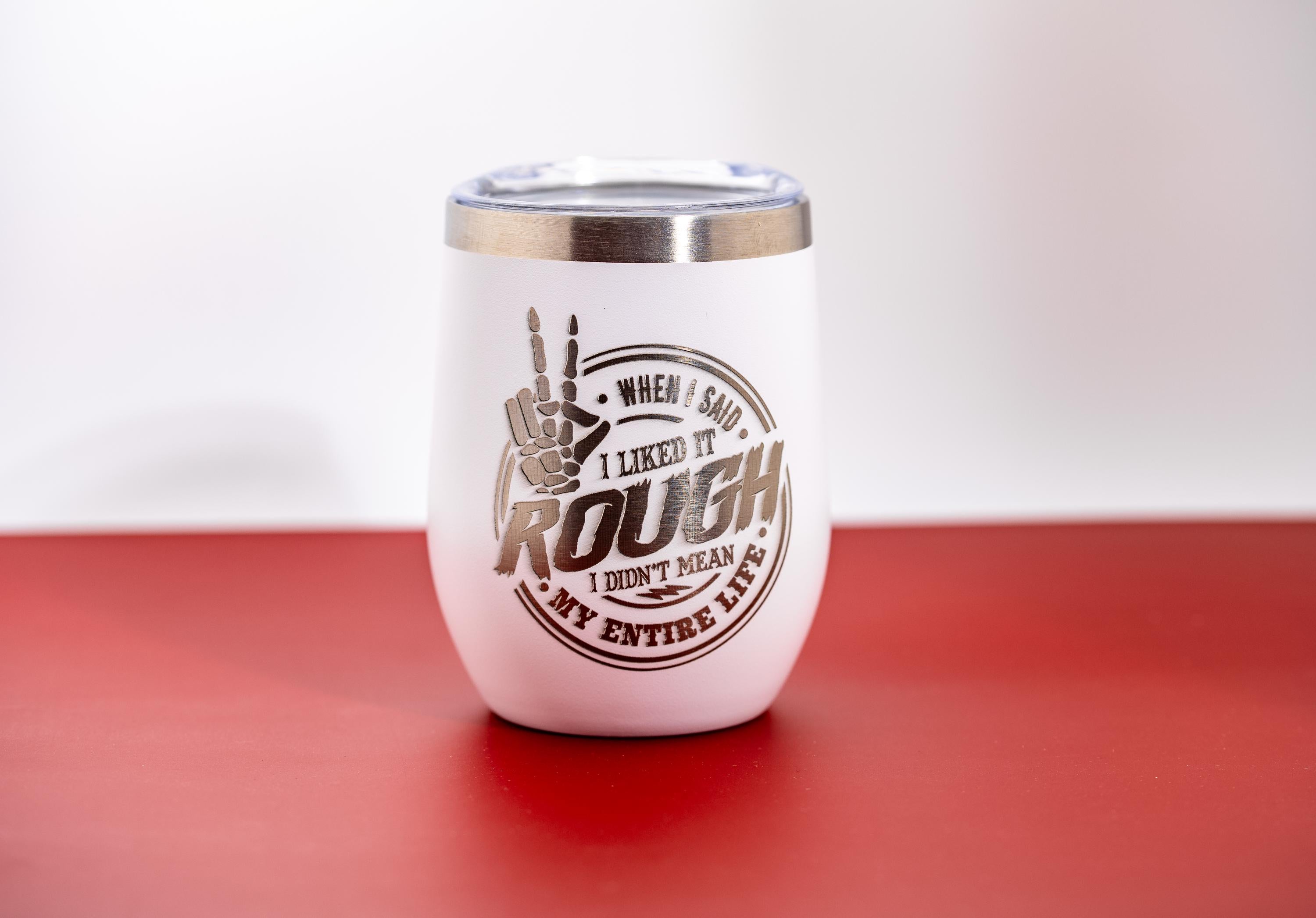 May include: White insulated tumbler with a silver rim and lid. The tumbler features a graphic with a peace sign hand gesture and the text "When I said I liked it rough, I didn't mean my entire life."