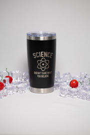 A black tumbler with the text "SCIENCE DOESN'T CARE WHAT YOU BELIEVE" printed on it, surrounded by ice cubes and cherry tomatoes.