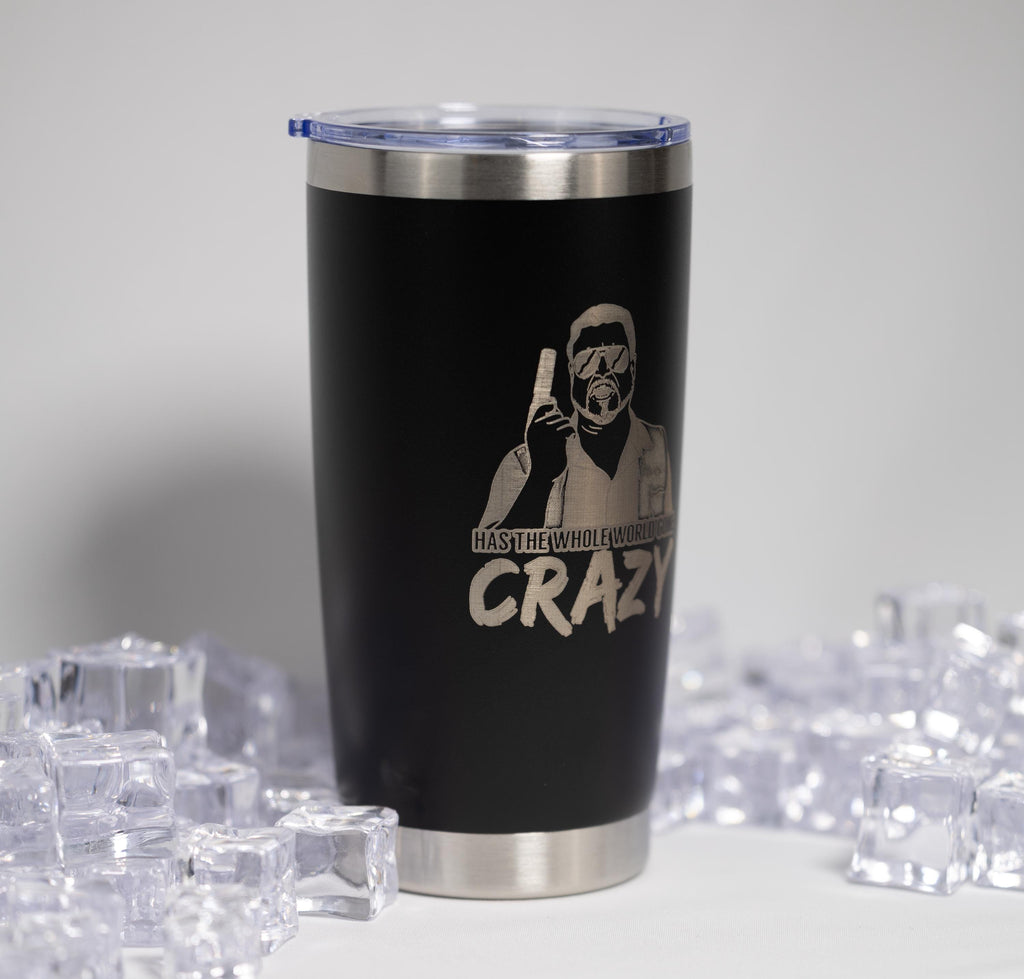 A black tumbler with a printed design and text on it, surrounded by ice cubes.