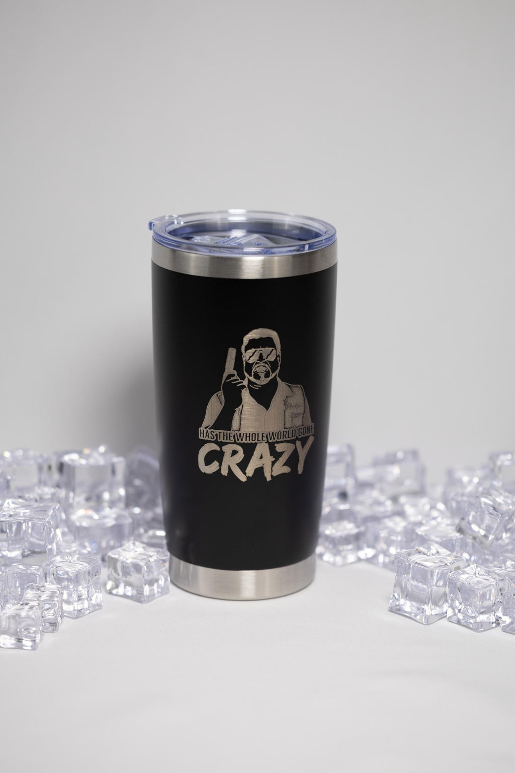 A black tumbler with a lid and a printed design on it, surrounded by ice cubes.