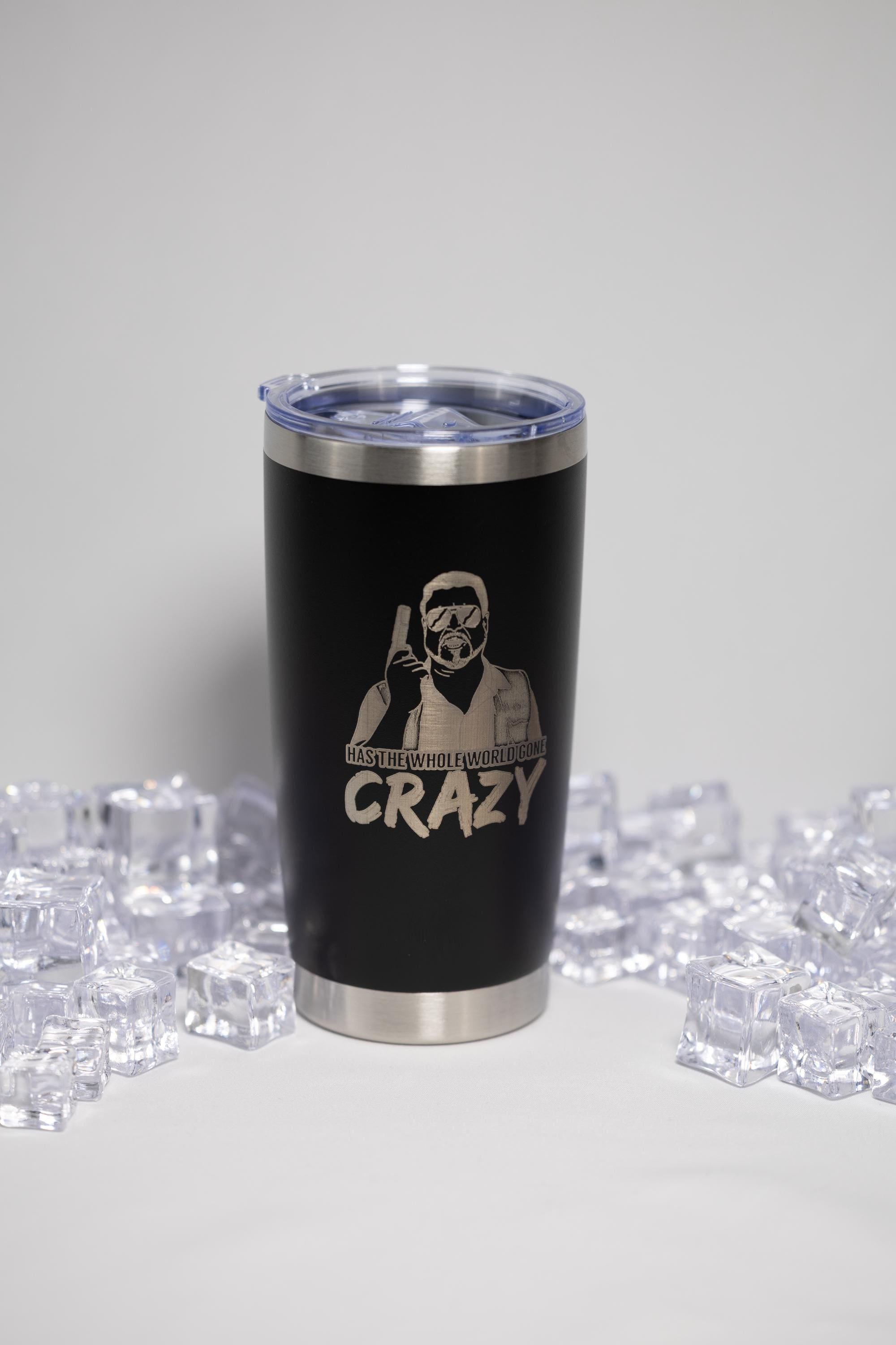 A black tumbler with a lid and a printed design on it, surrounded by ice cubes.